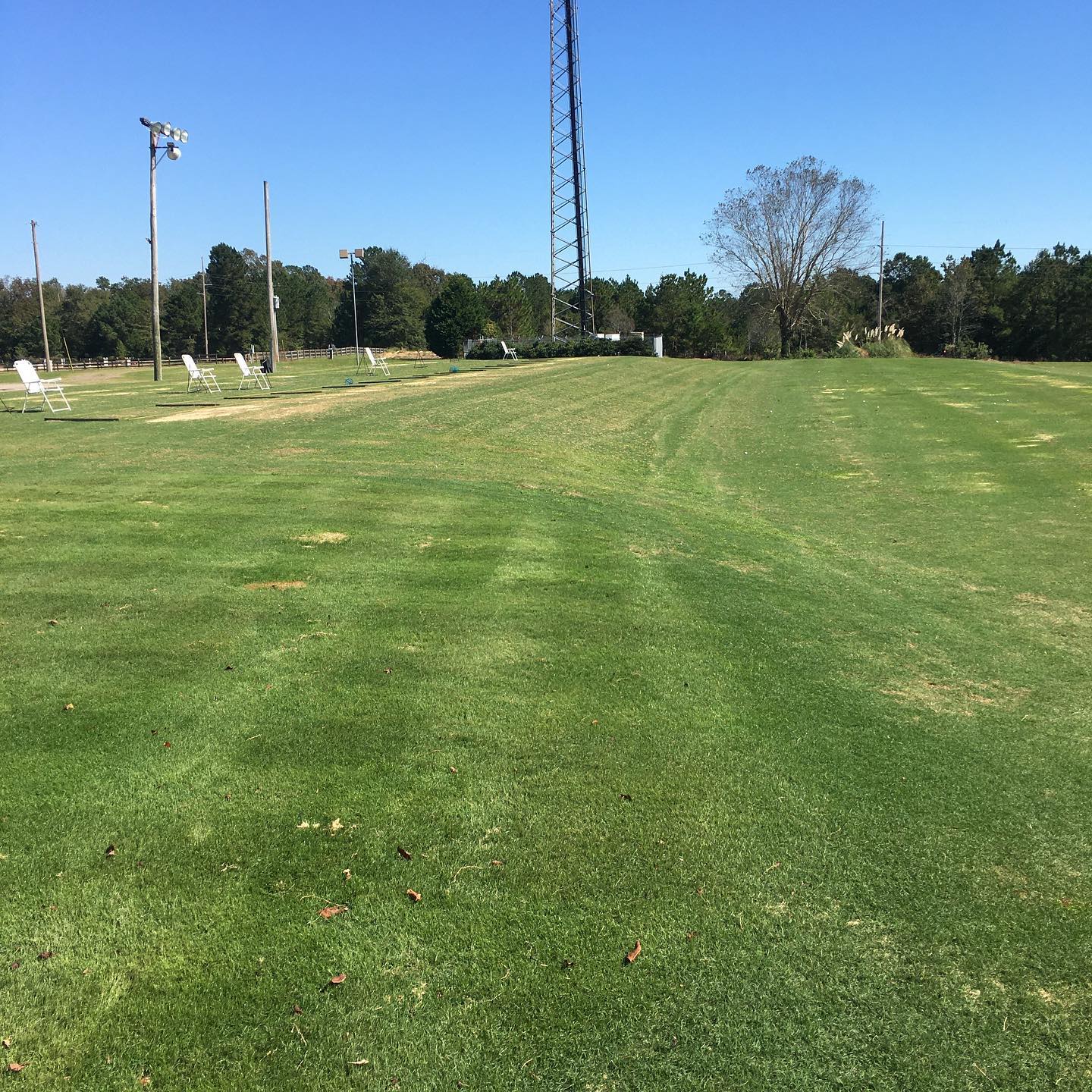 Golfer mid-swing in a bay at Carolina Golf Range